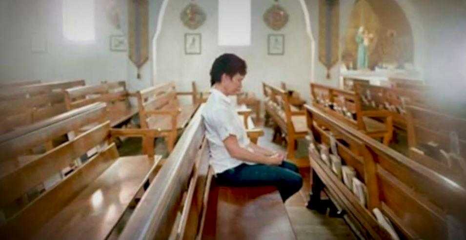 Photo of Debby sitting on a church pew in quiet reflection.